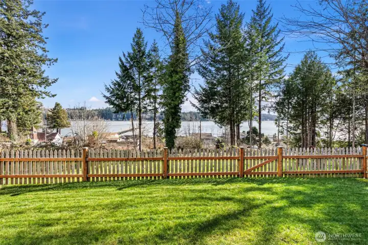 Enjoy marine views from the yard, covered porch, living room, dining, kitchen, and primary suite.