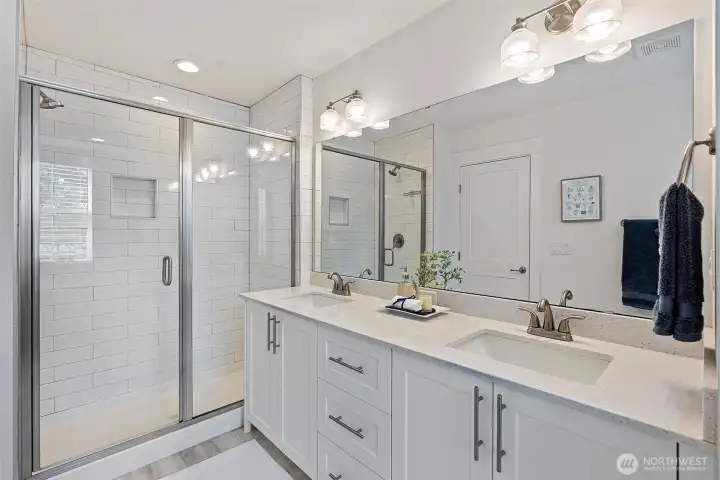 The bath countertops are quartz, and the shower features subway tiles.