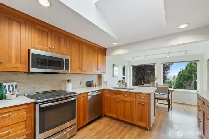 Beautiful light-filled kitchen featuring quartz countertops, cherry wood cabinets and stainless appliances. Beautiful light-filled kitchen featuring quartz countertops, cherry wood cabinets and stainless appliances.