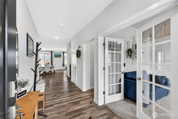 Light and bright entry featuring vinyl plank flooring.  French doors lead to main floor office