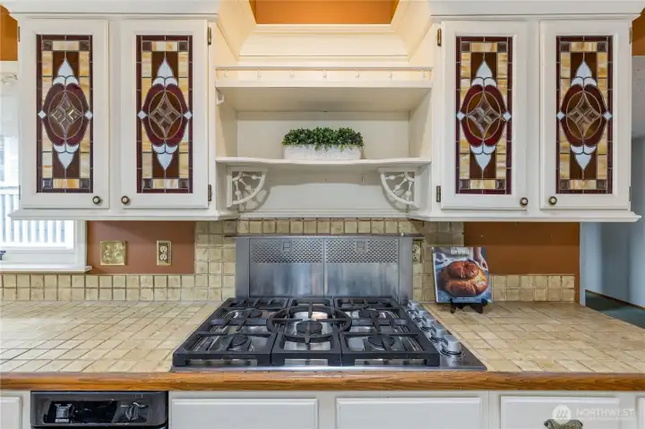 Chef's kitchen is highlighted by a 5-burner gas range and custom stained glass cabinetry