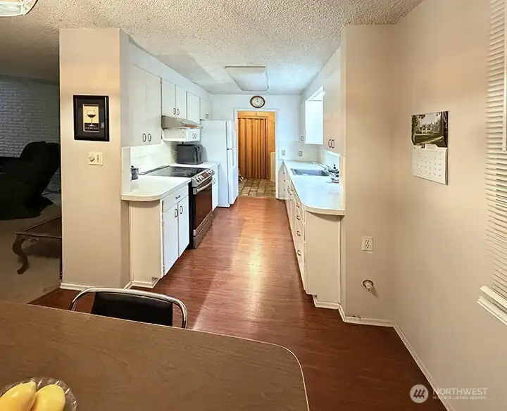 Looking from the eating area into the kitchen. Beyond the door in the distance is a surprisingly useful pantry area that has cupboards and additional counter space. This might be one areas to consult a designer for suggestions about expanding the kitchen.
