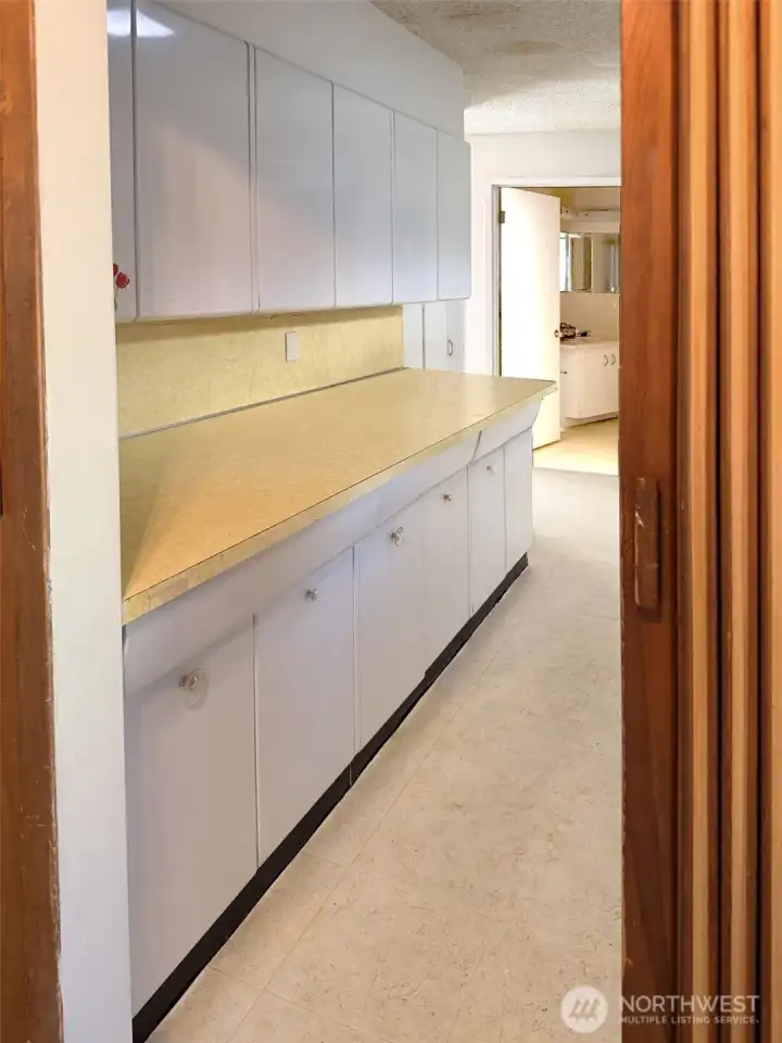This is the pantry area off the kitchen allowing you lots of storage for things that might not fit in the kitchen space. Place your non essential kitchen items in here. Just a few steps away from the kitchen. To the right, not seen in this photo is the washer and dryer, a laundry sink and storage closet. (see next photo)
