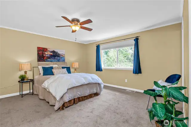 Large primary bedroom with ceiling fan ...