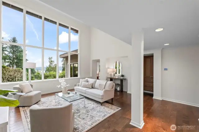 Stunning entrance into the living room with soaring ceilings windows that showcase the view of the Puget Sound.