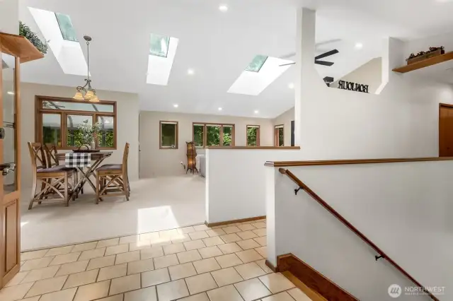 Step inside to discover an expansive main level offering approximately 1,880 square feet of warm, light-filled living. Vaulted cathedral ceilings and multiple skylights elevate the space, while large windows bring the beauty of the outdoors in.