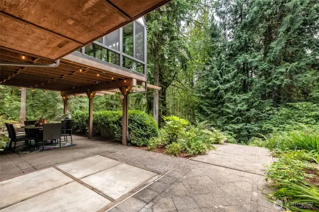 Sliding doors from the family room lead out to a covered patio, perfect for year-round enjoyment. A concrete pad is already in place for a hot tub, and surrounding pathways offer even more opportunities to explore the natural beauty of the property.