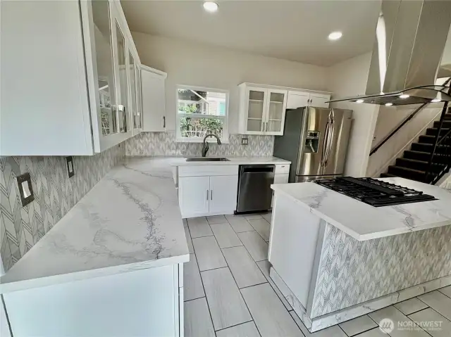 Quartz counters and a center island with gas stove.