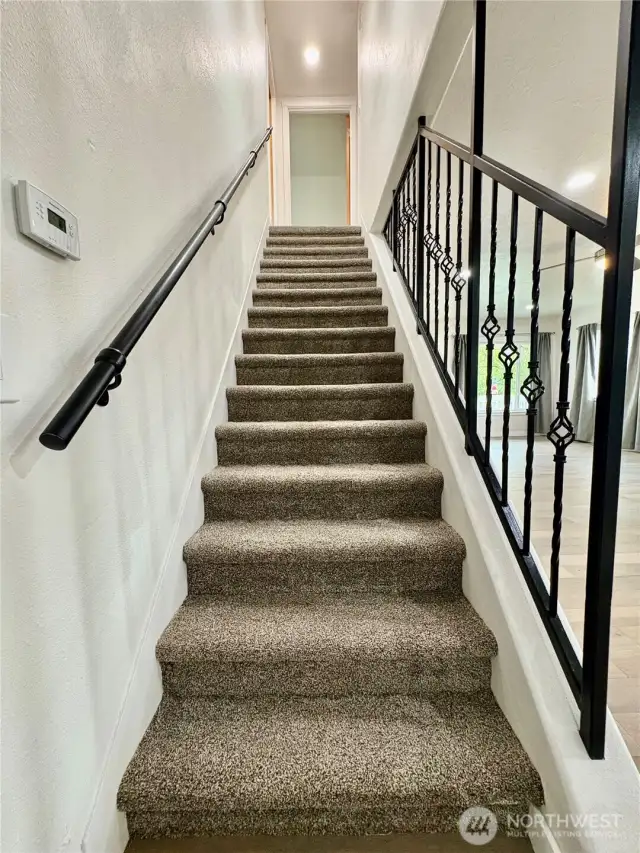 Custom handrail and new carpet leads  to the upper floor.