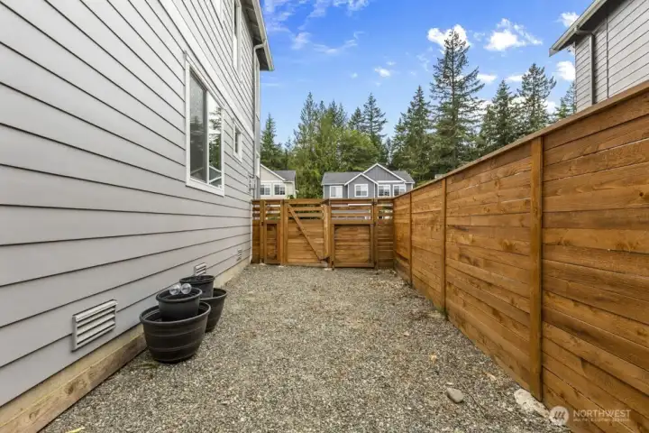 On the side of the home, a gravel section with a double gate fully opens—ideal for storing smaller recreational toys and gear.