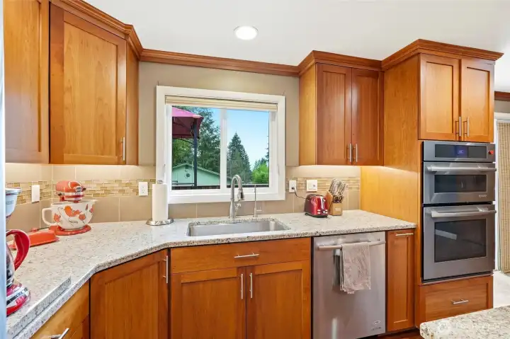 Granite countertops and window overlooking your private backyard