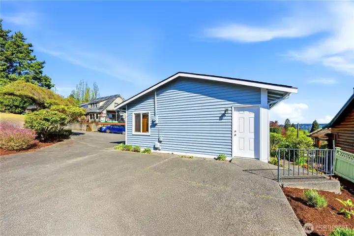 Side of garage with man door. Walkway to the right goes along the side of the house to a door to the roughed-in basement.