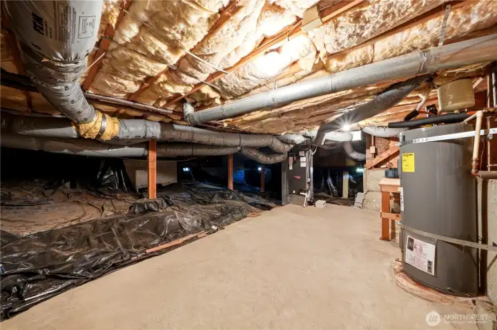 Insulated like crazy! Here is where the hot water tank and the furnace are situated on a concrete floor. There is also a workbench past the hot water tank to the right. Head height is good down here.