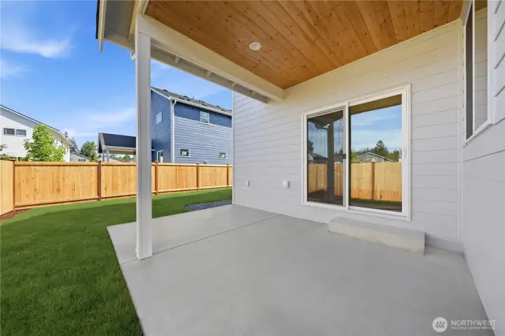 Fully fenced backyard with a covered patio