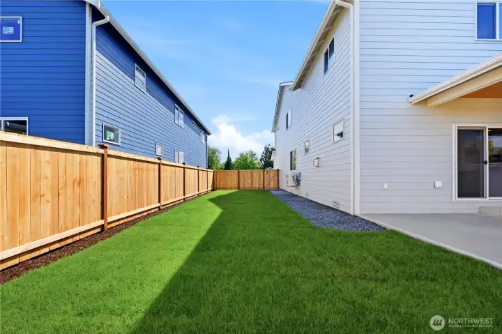 Fully fenced backyard with a covered patio