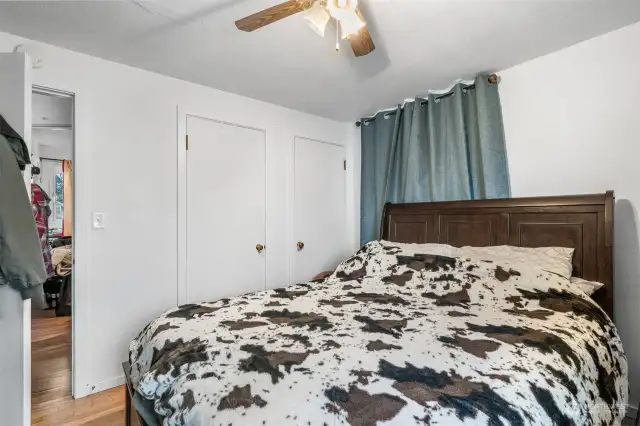 First bedroom with windows looking to both the front yard and side yard. His and her closets. Ceiling fan.