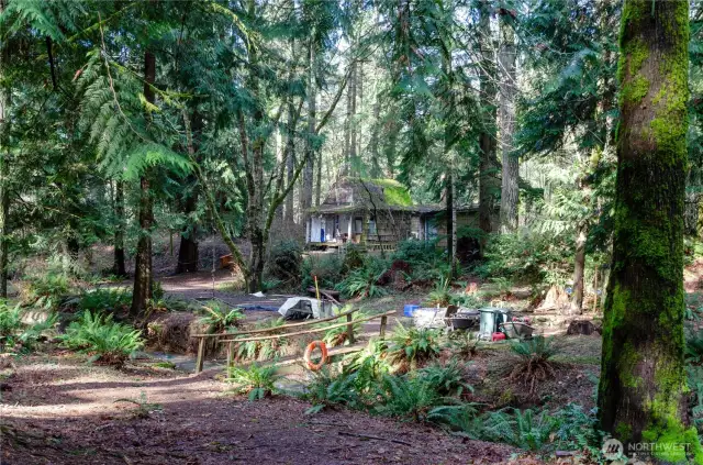 A small cabin built years ago with one of two bridge crossings over the natural creek