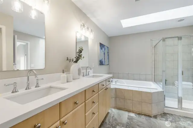 Soaking Tub with Updated Quartz Countertops, New Mirror, and Contemporary Lighting Fixtures