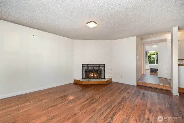 Living room features a cozy corner fireplace, adding warmth and charm to the space.