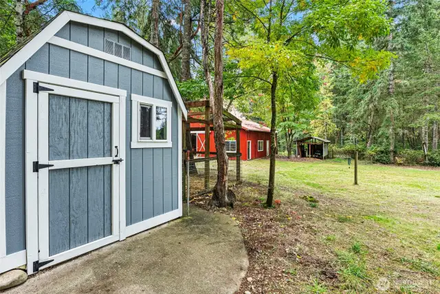 Close up of the chicken coop with barn in the background.