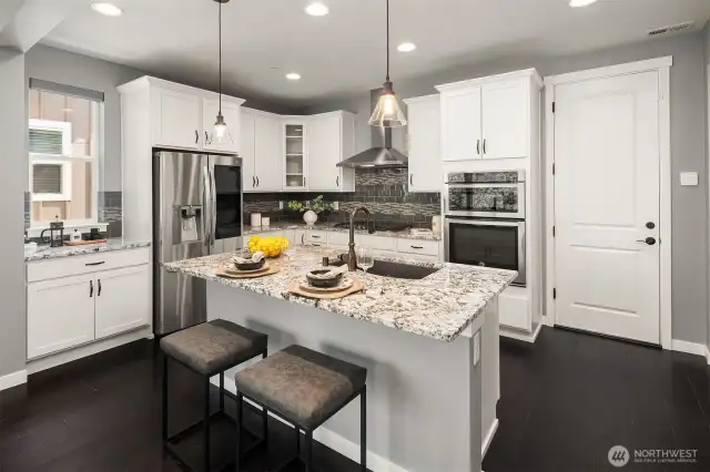 Kitchen with slab granite countertops and SS appliances