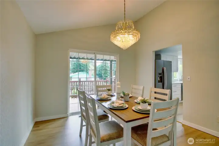 Large dining room with slider out to multi level deck.