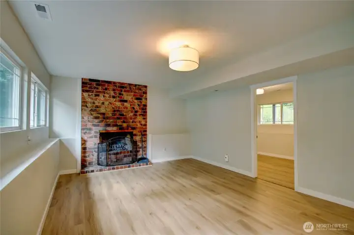 Large recroom with wood burning fireplace and shows bedroom #4