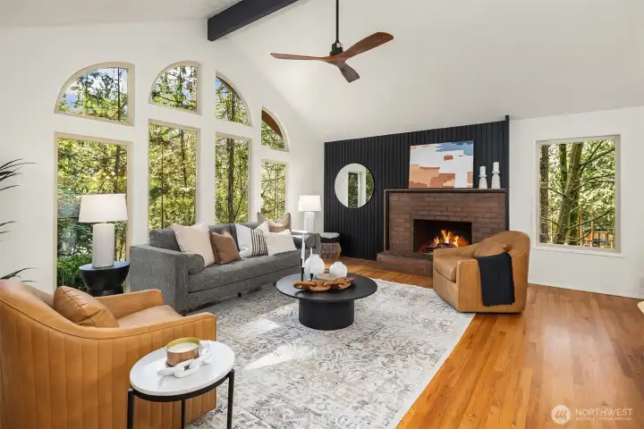The great room featuring soaring ceilings, beautiful light   & a refinished, moody gas fireplace.