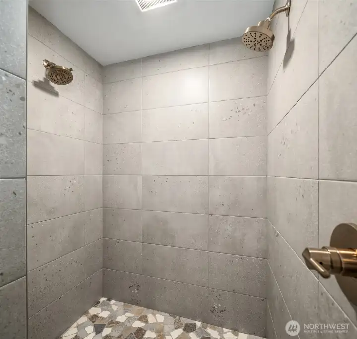 Primary walk-in shower with river rock & dual shower heads.