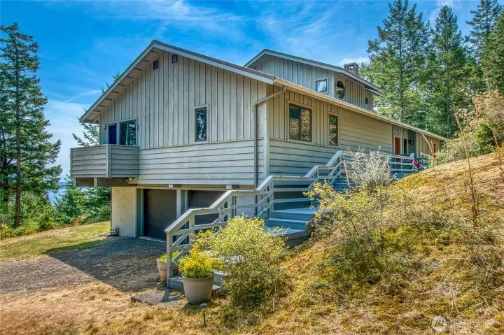 North side of home with garage entrance and the primary suite's balcony. North side of home with garage entrance and the primary suite's balcony.