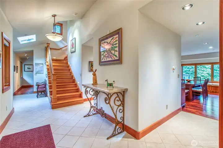 Durable tiled foyer showing hall at left to two bedrooms, stairs to upper suite, dining area 8n the distance. Center area houses a pantry and storage closet. According to the blueprints, this area was designed for a future elevator Durable tiled foyer showing hall at left to two bedrooms, stairs to upper suite, dining area 8n the distance. Center area houses a pantry and storage closet. According to the blueprints, this area was designed for a future elevator