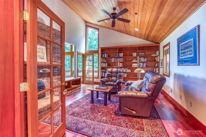 Beautiful library through French doors off the Foyer. Built-in shelves, T&G wood ceilings, Brazillian cherry floors and a brick fireplace add to the cozy feel, while windows and openings to the great room keep the space light. Beautiful library through French doors off the Foyer. Built-in shelves, T&G wood ceilings, Brazillian cherry floors and a brick fireplace add to the cozy feel, while windows and openings to the great room keep the space light.