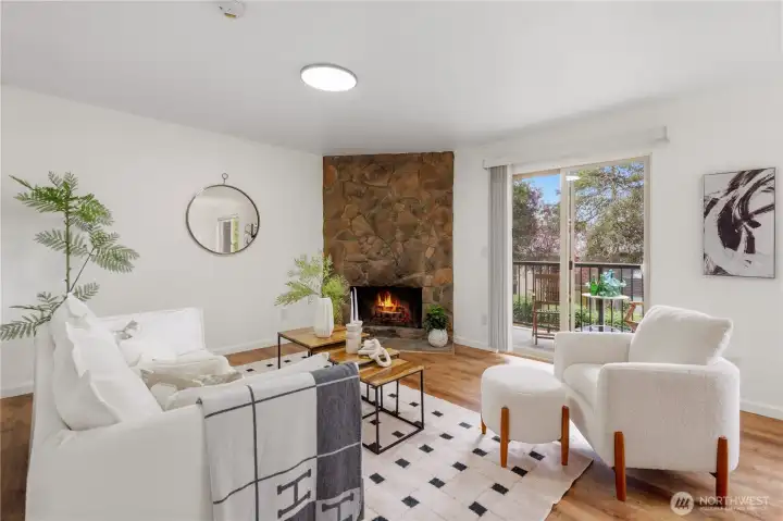 Living room with wood-burning fireplace and sliding door to covered balcony. Living room with wood-burning fireplace and sliding door to covered balcony.