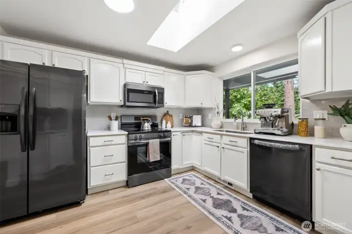 updated kitchen with quartz countertops and tile backsplash