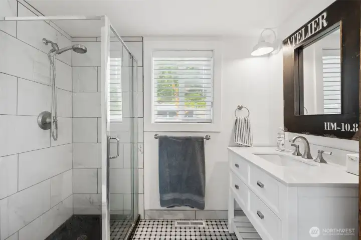 Main floor 3/4 bath with custom cabinet and tile floors.