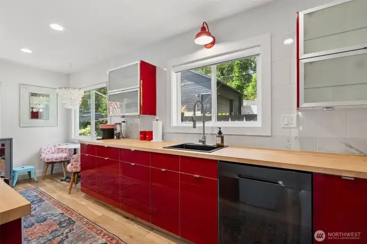 Bright, welcoming, and full of character, the kitchen's cheerful red cabinets create a fun focal point that perfectly complements the home's unique personality. Whether you're preparing fresh seafood after a day on the water or gathering friends for happy hour, this lively kitchen is sure to leave a lasting impression.
