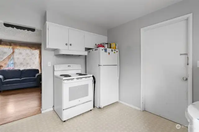 Refrigerator and stove stay! Doorway opens to the attached garage.