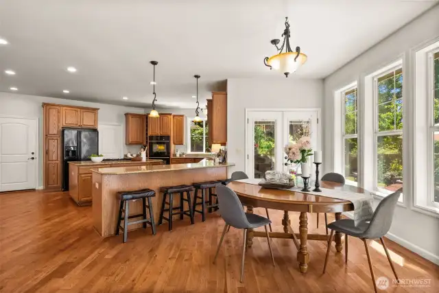 A bright and spacious informal dining area off the kitchen features direct access to the backyard, allowing for seamless indoor-outdoor living. Peninsula seating are convenient for a quick bit or overflow seating.