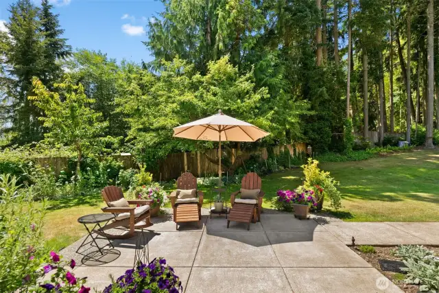 Towering pines in the backdrop offer much-needed shade to keep the grass lush all summer long, while also enhancing privacy.