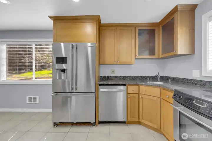 Updated kitchen with newer cabinetry, stainless steel appliances, and casual dining island in Bothell condo.