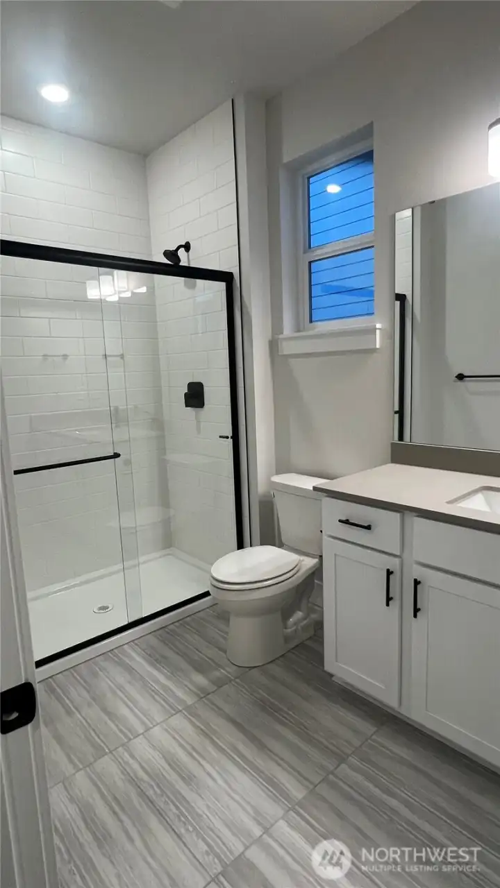 Basement bathroom with walk in shower, & large tile floors