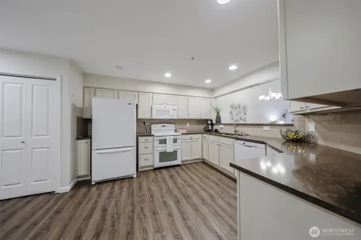 Beautiful cream colored  cabinets, quartz countertops, full height tile backsplash, newer appliances