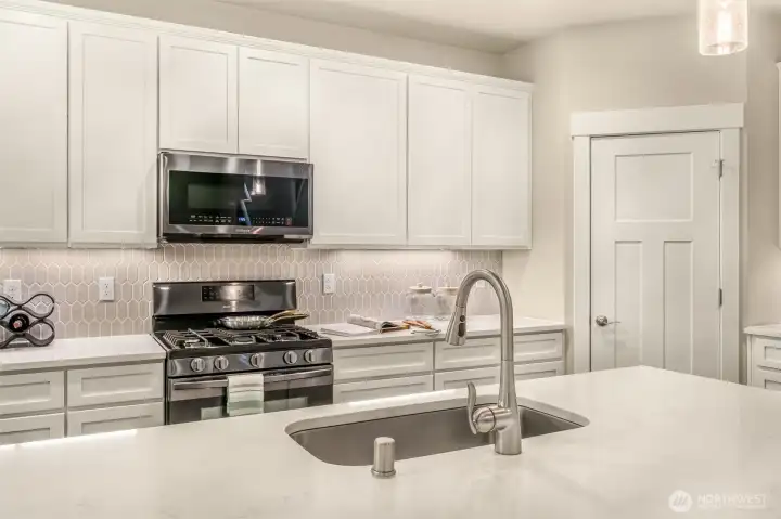 Gleaming countertops, gas cookig and stainless appliances