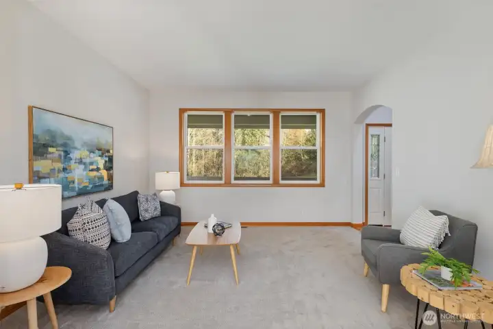 Enjoy the comfort of the spacious living room with peaceful, private views of the nature-filled front yard.