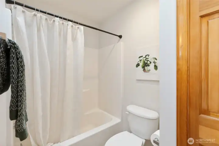 Upstairs full bathroom featuring a tub/shower combination and generous linen closet storage.