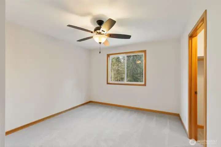 Another impressive upstairs bedroom with a roomy walk-in closet and ceiling fan for comfort.