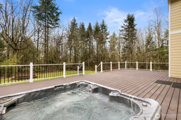 Outdoors, relax and unwind in the top-of-the-line hot tub on the expansive Trex deck, surrounded by tranquil woodland views.