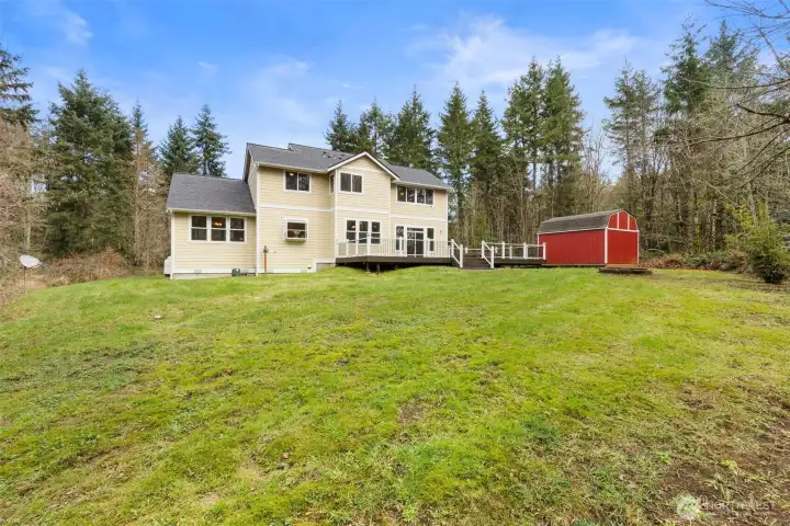 The backyard is perfect for outdoor living and entertaining, featuring a deck ideal for dining and relaxing, with a convenient outdoor shed for storage or hobbies.