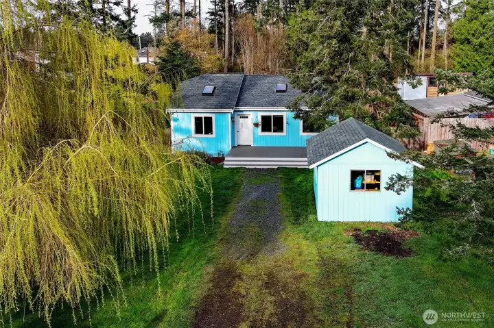 Aerial view showcasing the charming front of the home and convenient detached outbuilding.