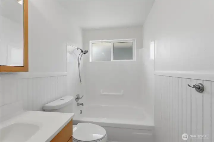 Bathroom with refreshed tub and tile surround.
